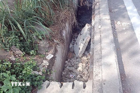 Các tấm đan đậy rãnh thoát nước trên Xa lộ Hà Nội và Quốc lộ 1 đoạn qua thành phố Thủ Đức bị đập phá. (Ảnh: TTXVN phát)