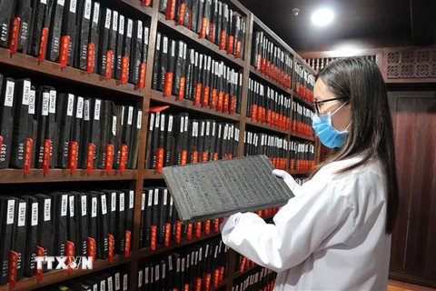 Cán bộ Trung tâm Lưu trữ Quốc gia IV kiểm tra các Mộc bản đang lưu trữ. (Ảnh: Quốc Hùng/TTXVN)