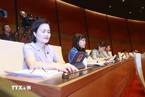 Đoàn đại biểu Quốc hội tỉnh Quảng Ninh ấn biểu quyết qua Luật Giao dịch điện tử (sửa đổi). (Ảnh: Doãn Tấn/TTXVN)