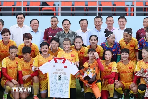 Thủ tướng Phạm Minh Chính chụp ảnh lưu niệm với các cầu thủ và Ban Huấn luyện, các thành viên của Đội tuyển Bóng đá Nữ Quốc gia Việt Nam. (Ảnh: Dương Giang/TTXVN) 