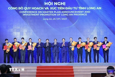 Thủ tướng Phạm Minh Chính chứng kiến trao chứng nhận đăng ký đầu tư của tỉnh Long An cho các nhà đầu tư. (Ảnh: Dương Giang/TTXVN)