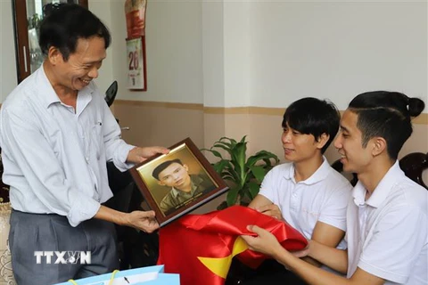 Đại diện nhóm TeamLee trao ảnh phục dựng truyền thần cho thân nhân liệt sỹ Nguyễn Chính (1937-1964). (Ảnh: Phan Sáu/TTXVN)