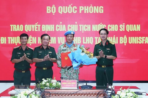 Thượng tướng Hoàng Xuân Chiến trao Quyết định của Chủ tịch nước cho Trung tá Đặng Quốc Tuấn đi thực hiện nhiệm vụ gìn giữ hòa bình Liên hợp quốc. (Ảnh: Trọng Đức/TTXVN)