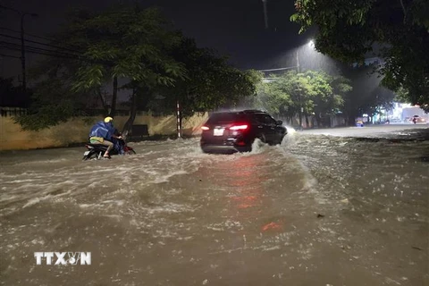Các phương tiện di chuyển khó khăn trên đoạn đường ngập sâu ở thành phố Điện Biên Phủ. (Ảnh: Xuân Tư/TTXVN)