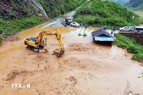 Máy múc được huy động để san gạt bùn, đất, đá bị sạt lở tại bản Nà Lếch, xã Chiềng Lao, huyện Mường La. (Ảnh: Quang Quyết/TTXVN)