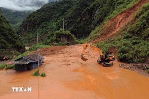 Máy múc được huy động để san gạt bùn, đất, đá bị sạt lở tại bản Nà Lếch, xã Chiềng Lao, huyện Mường La, tỉnh Sơn La. (Ảnh: Quang Quyết/TTXVN)