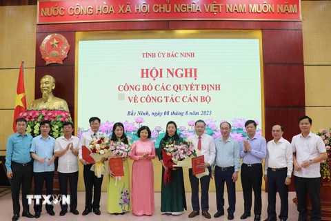 Chủ tịch Ủy ban Nhân dân tỉnh Bắc Ninh Nguyễn Hương Giang trao quyết định và tặng hoa chúc mừng các cán bộ nhận nhiệm vụ mới. (Ảnh: Thái Hùng/TTXVN)