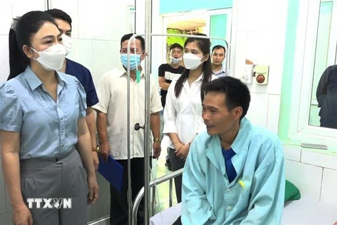Phó Chủ tịch UBND huyện Xín Mần Vũ Thị Hòa thăm hỏi, động viên các bệnh nhân bị ngộ độc do ăn hoa chuông. (Ảnh: TTXVN phát)