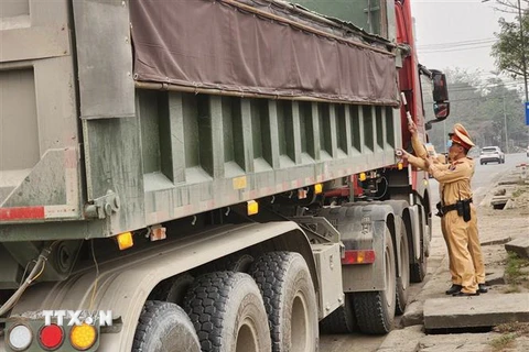 Cảnh sát giao thông Công an thành phố Hà Nội kiểm tra nhằm phát hiện phương tiện chở quá tải, cơi nới thành thùng xe. (Ảnh: TTXVN phát)