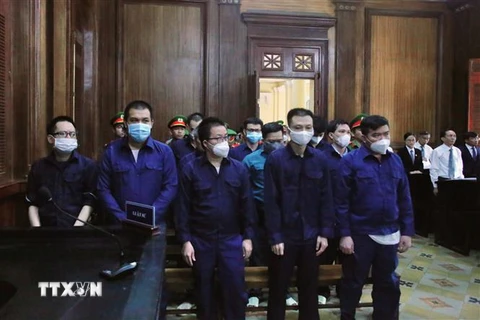 13 cựu cán bộ Công an phường Phú Thọ Hòa tại tòa. (Ảnh: Thành Chung/TTXVN)