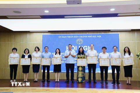 Lãnh đạo thành phố Hà Nội trao bằng khen cho các cá nhân có thành tích xuất sắc. (Ảnh: TTXVN phát)