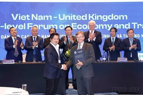 Chủ tịch Quốc hội Vương Đình Huệ chứng kiến lễ trao các thỏa thuận hợp tác giữa các doanh nghiệp, địa phương hai nước tại Diễn đàn Cấp cao Việt Nam-Vương quốc Anh về Kinh tế và Thương mại tháng 6/2022. (Ảnh: Doãn Tấn/TTXVN)