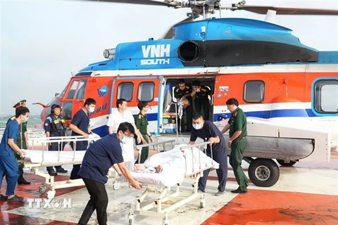 Ba nạn nhân bị giảm áp khi đánh bắt hải sản ở vùng biển Trường Sa được trực thăng đưa về đất liền an toàn. (Ảnh: TTXVN phát)
