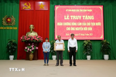 Tặng 'Huân chương Dũng cảm' của Chủ tịch nước cho đại diện gia đình anh Nguyễn Hữu Đốn. (Ảnh: Nguyễn Thanh/TTXVN)