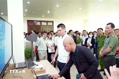 Các đại biểu tham quan mô hình ứng dụng căn cước công dân gắn chip điện tử, VNEID phục vụ kiểm soát an ninh và chấm công tại Công ty Cổ phần Ximăng Xuân Thành. (Ảnh: Nguyễn Chinh/TTXVN)