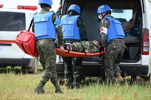 Lực lượng y tế diễn tập cấp cứu công binh bị thương khi thực hiện nhiệm vụ rà phá bom mìn, vật nổ tại trại tị nạn. (Ảnh: TTXVN phát)