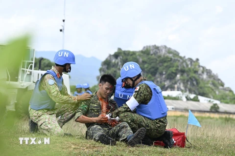 Lực lượng y tế nhanh chóng sơ cứu công binh bị thương trong khi làm nhiệm vụ. (Ảnh: TTXVN phát)