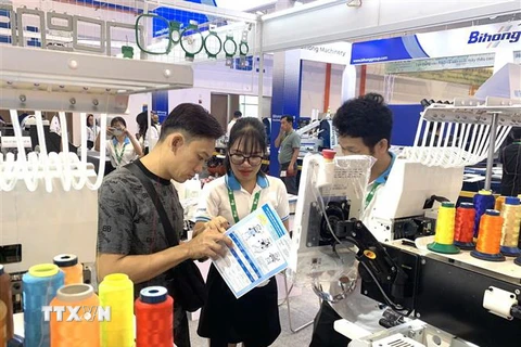 Khách tham quan các gian hàng tại Triển lãm Quốc tế Thiết bị, Công nghệ In thêu, Sản phẩm và Nguyên phụ liệu Dệt may tại Việt Nam. (Ảnh: Huyền Trang/TTXVN)