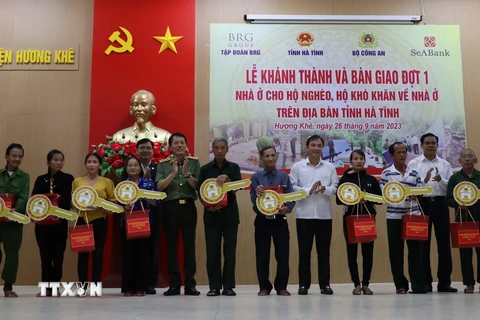 Thứ trưởng Bộ Công an Lương Tam Quang, lãnh đạo tỉnh Hà Tĩnh và nhà tài trợ Tập đoàn BRG, Ngân hàng SeABank trao tặng quà và biểu trưng chìa khóa nhà cho các hộ dân ở huyện Hương Khê. (Ảnh: Hoàng Ngà/TTXVN)