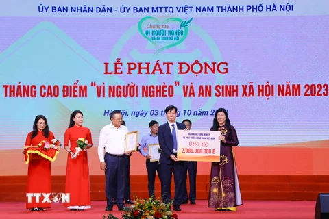 Chủ tịch UBND thành phố Hà Nội Trần Sỹ Thanh và Chủ tịch Ủy ban MTTQ Việt Nam thành phố Hà Nội Nguyễn Lan Hương tiếp nhận sự ủng hộ và trao tặng Thư cảm ơn ghi nhận sự ủng hộ của các đơn vị. (Ảnh: Văn Điệp/TTXVN)