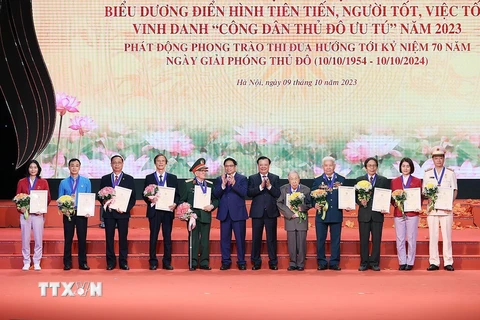Thủ tướng Phạm Minh Chính và Bí thư Thành ủy Hà Nội Đinh Tiến Dũng trao danh hiệu 'Công dân Thủ đô Ưu tú' năm 2023 cho các cá nhân. (Ảnh: Dương Giang/TTXVN)