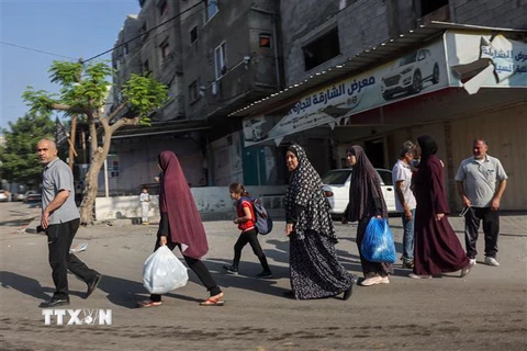 Người dân Palestine sơ tán tới các khu vực an toàn sau các cuộc không kích của Israel, ngày 13/10. (Ảnh: AFP/TTXVN)