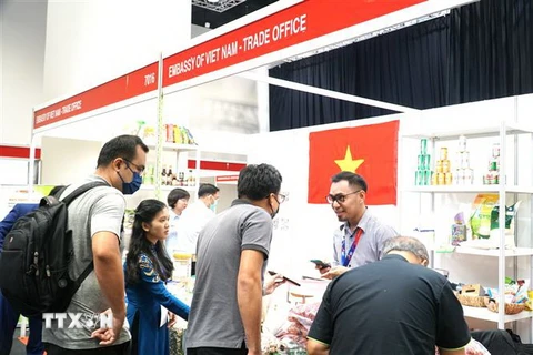 Đại diện của Thương vụ Việt Nam tại Malaysia giới thiệu sản phẩm hạt điều đến bạn bè quốc tế. (Ảnh: Hằng Linh/TTXVN)