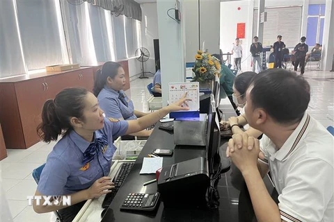 Hành khách lấy số thứ tự mua vé tàu Tết tại Ga Sài Gòn. (Ảnh: Tiến Lực/TTXVN)