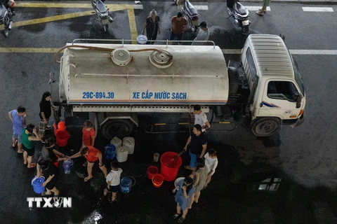 Xe nước sạch đến các hộ dân sinh sống tại Khu Đô thị Thanh Hà tối 20/10. (Ảnh: Hoàng Hiếu/TTXVN)