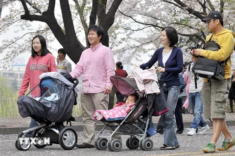 Các bố mẹ đưa con đi dạo tại Seoul, Hàn Quốc. (Ảnh: AFP/TTXVN)