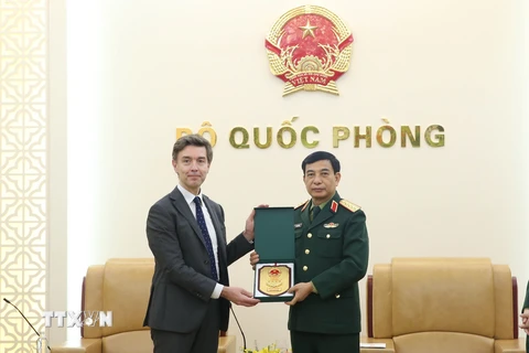 Đại tướng Phan Văn Giang tặng quà lưu niệm ông Julien Guerrier. (Ảnh: Hồng Pha/TTXVN phát)
