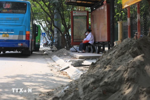 Cát, vật liệu xây dựng vỉa hè tràn ra đường Nguyễn Văn Huyên, quận Cầu Giấy gây mất an toàn giao thông. (Ảnh: Hoàng Hiếu/TTXVN)