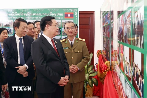 Chủ tịch Quốc hội Vương Đình Huệ xem trưng bày ảnh tại Học viện Chính trị Công an Lào. (Ảnh: Doãn Tấn/TTXVN)