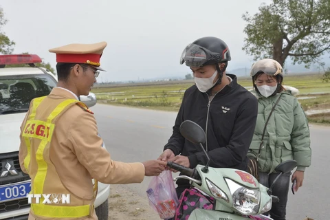 Lực lượng Cảnh sát Giao thông Công an tỉnh Điện Biên phát quà cho người dân trên đường về quê ăn Tết năm 2023. (Ảnh: Xuân Tư/TTXVN)
