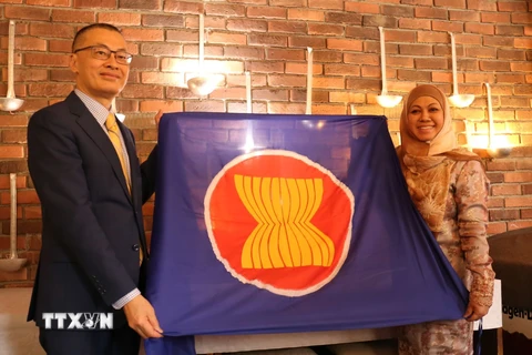 Đại sứ Việt Nam Vũ Quang Minh trao cờ ASEAN và chuyển giao vai trò Chủ tịch luân phiên Ủy ban ASEAN tại Berlin (BAC) cho Đại sứ Brunei Pengiran Krtini Pengiran Tahir. (Ảnh: Thu Hằng/TTXVN)