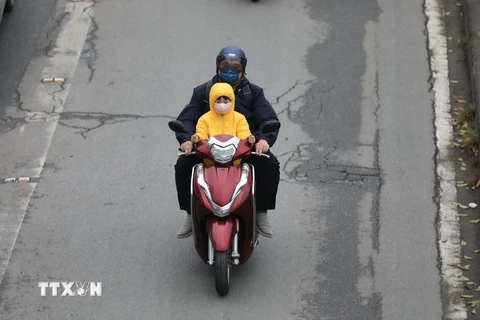 Người dân Thủ đô trang bị áo ấm khi tham gia giao thông. (Ảnh: Thanh Tùng/TTXVN)