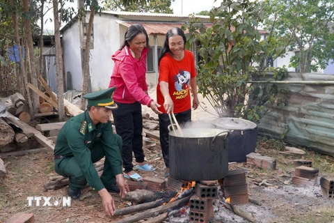 Bộ Chỉ huy Bộ đội Biên phòng tỉnh Kon Tum và bà con Gié Triêng tại làng Nông Kon, xã Đăk Dục cùng nhau luộc bánh chưng. (Ảnh: Khoa Chương/TTXVN)