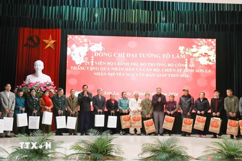 Đại tướng Tô Lâm và lãnh đạo tỉnh Sơn La trao quà tặng cho người có công trên địa bàn huyện Phù Yên. (Ảnh: TTXVN phát)