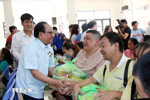 Ông Nguyễn Hữu Nhơn, Chánh Hội trưởng Nam Thành Thánh thất, trao quà Tết cho người nghèo, người có hoàn cảnh khó khăn trên địa bàn thành phố. (Ảnh: Xuân Khu/TTXVN)