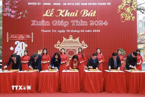 Các đại biểu thành phố Hà Nội thực hiện nghi thức khai bút. (Ảnh: TTXVN phát)
