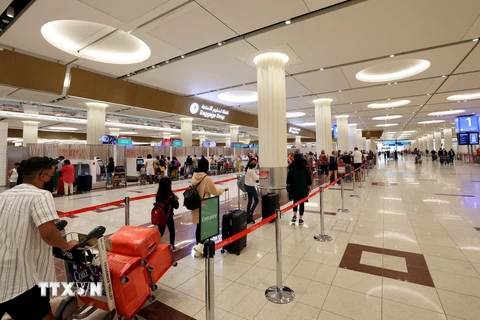 Hành khách làm thủ tục tại Sân bay Quốc tế Dubai. (Ảnh: AFP/TTXVN)