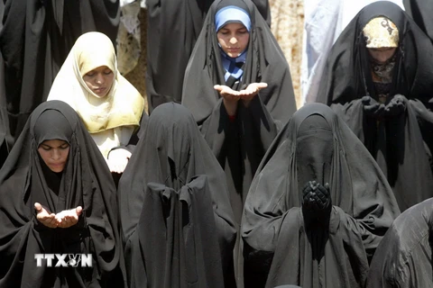 Phụ nữ Hồi giáo mặc áo choàng abaya tại một lễ cầu nguyện. (Ảnh: AFP/TTXVN)