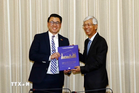 Phó Chủ tịch Ủy ban Nhân dân Thành phố Hồ Chí Minh Võ Văn Hoan (phải) tặng sách đối ngoại cho Thượng nghị sỹ Joseph Nguyen. (Ảnh: Xuân Khu/TTXVN)