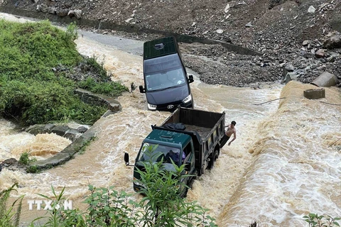 Nước lũ chảy xiết khiến một chiếc xe gặp nạn trên đường qua xã Pả Vi, huyện Mèo Vạc. (Ảnh: Trần Việt/TTXVN)