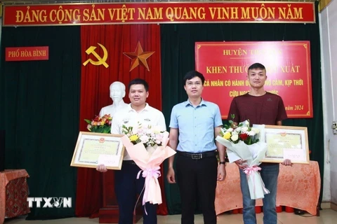 Ủy ban Nhân dân huyện Tiên Yên (Quảng Ninh) biểu dương, khen thưởng đột xuất 2 nam thanh niên dũng cảm cứu người. (Ảnh: TTXVN phát)