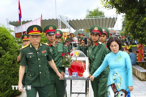 Đưa rước hài cốt liệt sỹ về truy điệu, an táng tại Nghĩa trang Liệt sỹ Tông Khao. (Ảnh: Xuân Tư/TTXVN)