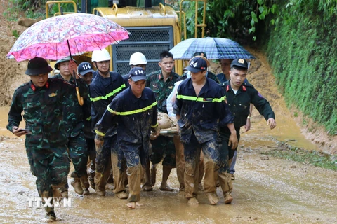 Lực lượng chức năng khẩn trương đưa các nạn nhân trong vụ sạt lở đi cấp cứu. (Ảnh: Đức Thọ/TTXVN)