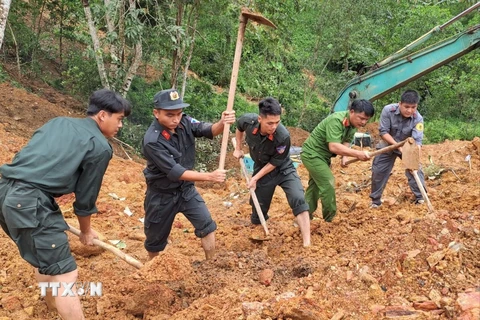 Các lực lượng chức năng khẩn trương tìm kiếm các nạn nhân đang bị vùi lấp. (Ảnh: Đức Thọ/TTXVN)