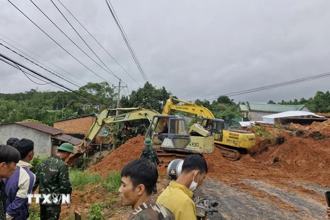 Lực lượng chức năng cùng thiết bị cơ giới triển khai công tác cứu hộ, giải tỏa hiện trường. (Ảnh: TTXVN phát)