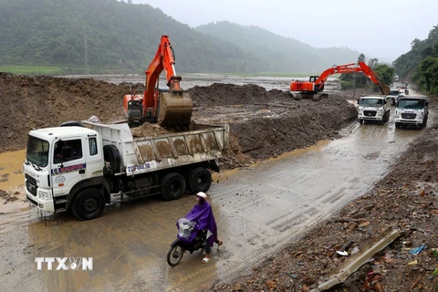 Các đơn vị ở Điện Biên bố trí nhiều máy móc, phương tiện để khắc phục sự cố, đảm bảo giao thông được thông suốt sau mưa lũ. (Ảnh: Trung Kiên/TTXVN)